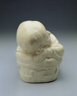 Pillow in the shape of a recumbent child with white glaze