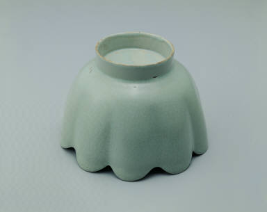 Warming bowl in the shaped of a flower with light bluish-green glaze