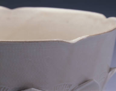 White glazed bowl with lotus petal decoration in relief and Guan mark
