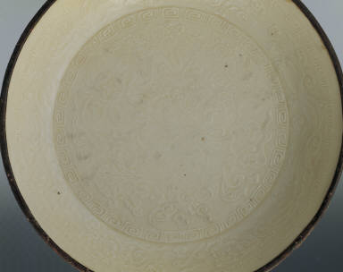 Dish impressed with design of playing lion in white glaze