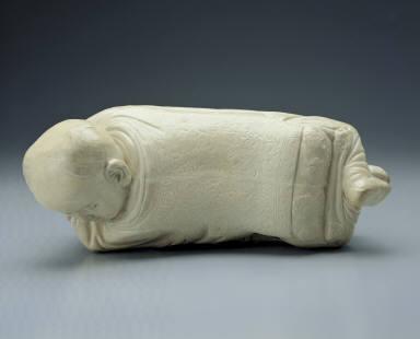 Pillow in the shape of a recumbent child with white glaze