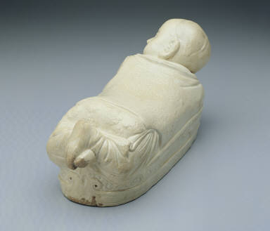 Pillow in the shape of a recumbent child with white glaze