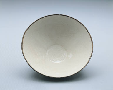 Hibiscus-rimmed bowl with impressed design of lotus pond and fish in white glaze