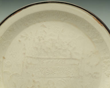 Dish with impressed scene of children at play in white glaze