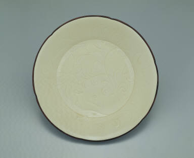 Hibiscus-rimmed dish with incised lotus design in white glaze