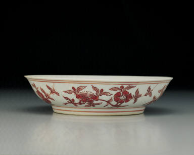 Dish with flowers and fruits in red enamel