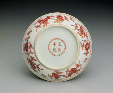 Dish with flowers and fruits in red enamel