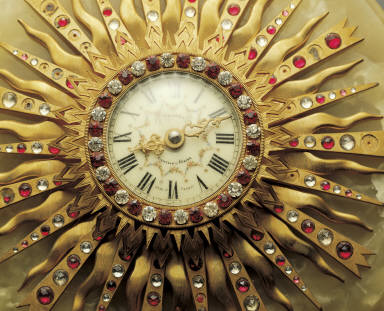 Gilt colck in the shape of sun