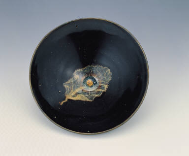 A temmoku bowl with a leaf pattern